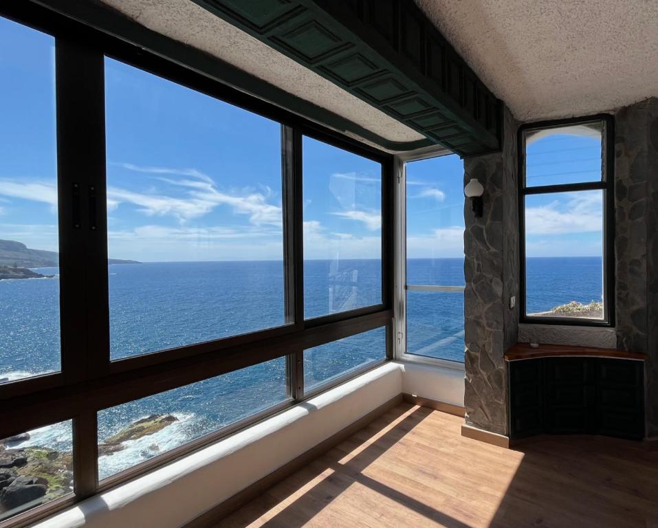 a room with windows looking out at the ocean at Sea lover's nest in Los Realejos