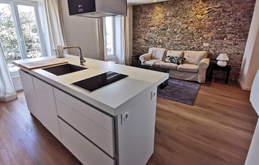 eine Küche mit einem Waschbecken und ein Wohnzimmer in der Unterkunft LE YACHTING a 150m de la Grande Plage in Les Sables-dʼOlonne