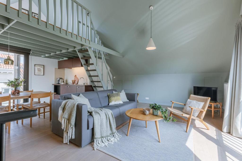 a living room with a blue couch and a table at Bonrepo Room 105 in Bruges