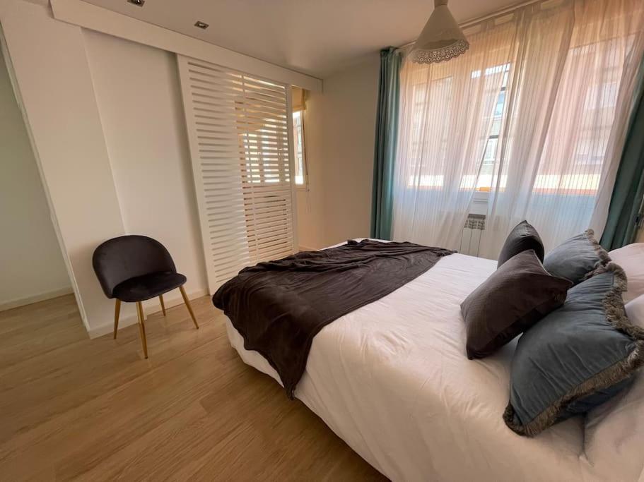 1 dormitorio con 1 cama, 1 silla y 1 ventana en MyHouseSpain - Ático con terraza en la playa, en Gijón