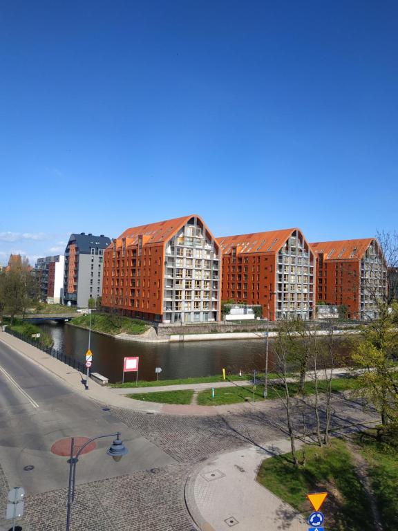 グダニスクにあるMaya's Apartmentsの建物と川のある街の景色