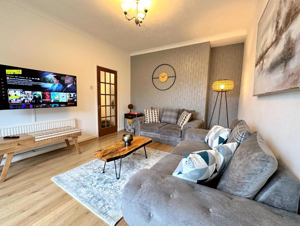 a living room with a couch and a table at Large house on the edge of the Brecon Beacons in Beaufort