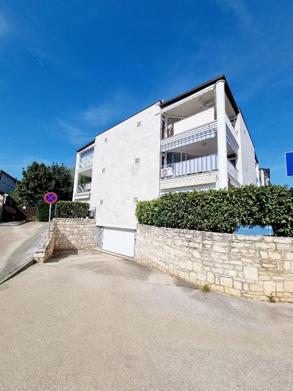 a white building with a stone wall at Sea view App Mirta in Umag