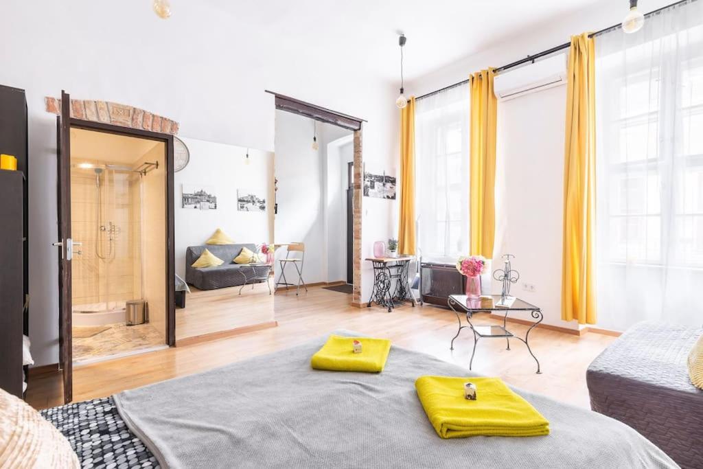 ein Zimmer mit einem Bett mit zwei gelben Kissen darauf in der Unterkunft Vintage Style Cozy Downtown Apartment. in Budapest