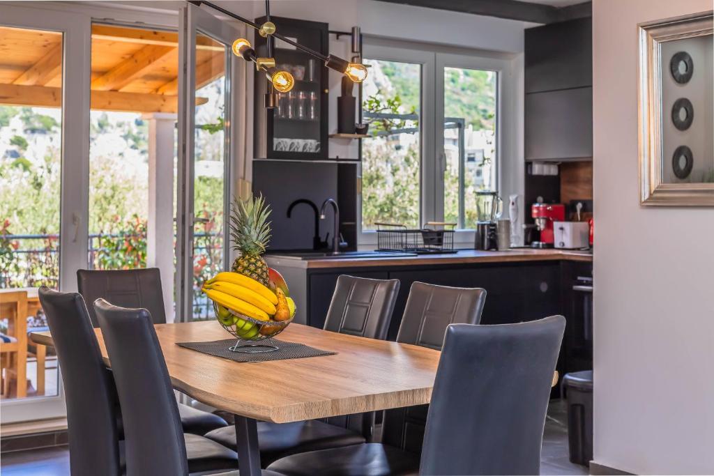 a kitchen and dining room with a wooden table and chairs at Downtown Deluxe in Omiš