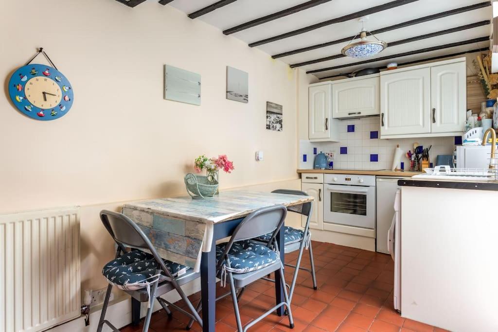 a kitchen with a table and chairs in a room at Cute Fisherman's Cottage in the Heart of Brighton in Brighton & Hove