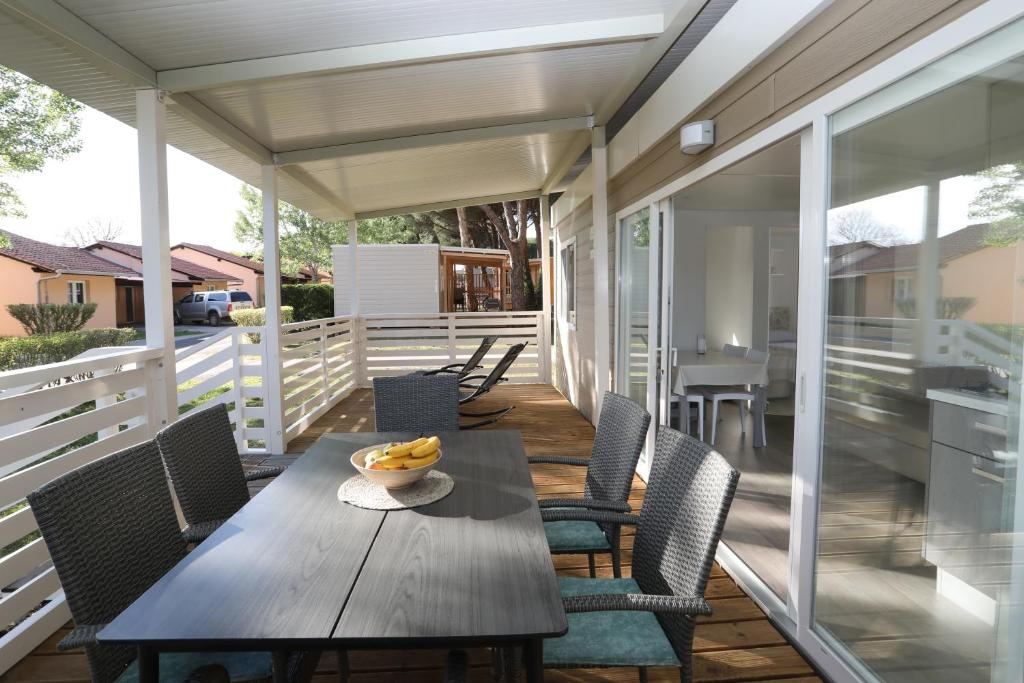a porch with a wooden table and chairs at Mobile home Istra BI VILLAGE in Fažana