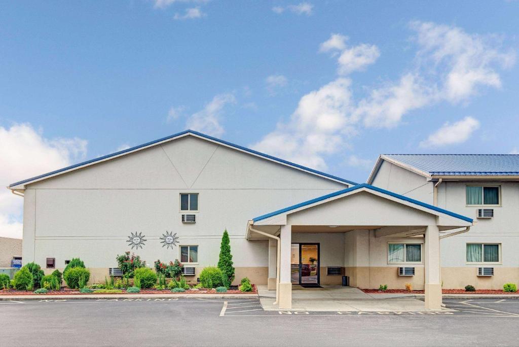 a large white building with a parking lot at Super 8 by Wyndham Indianapolis Emerson in Indianapolis