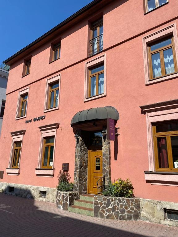 un edificio de ladrillo rojo con puerta amarilla en Hotel Majovey, en Žilina