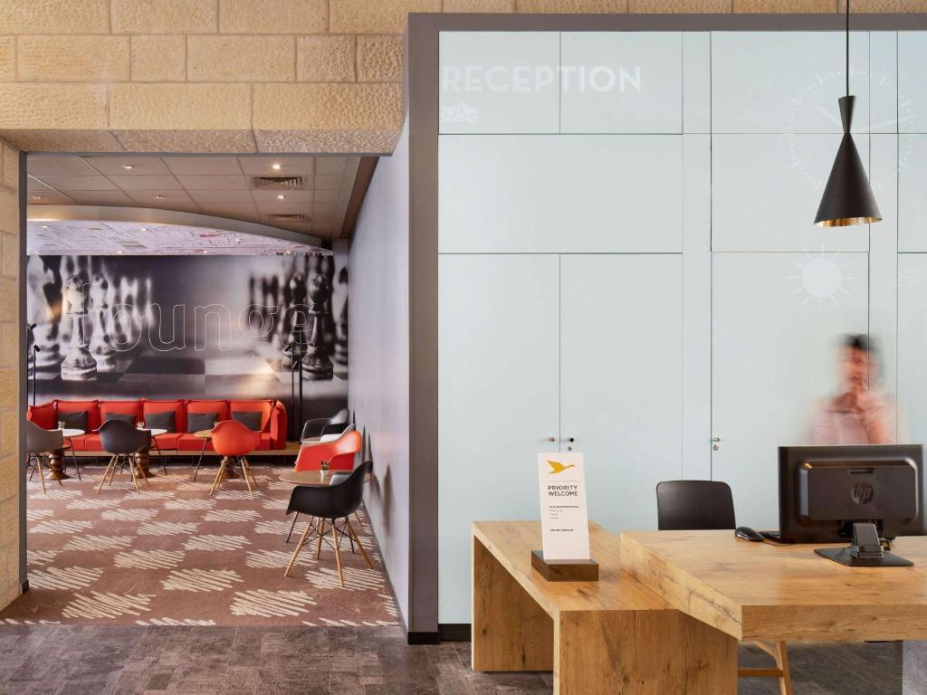 a lobby with a waiting room with red chairs at ibis Jerusalem city Center - An AccorHotels Brand in Jerusalem