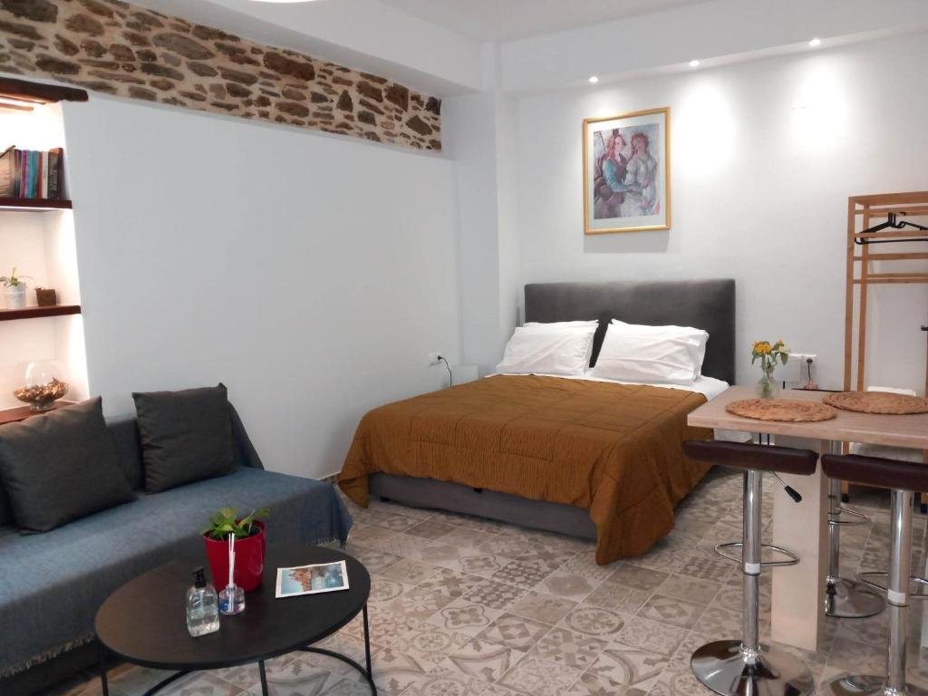 1 dormitorio con 1 cama y 1 sofá en Nisos suite, en Ermoupoli