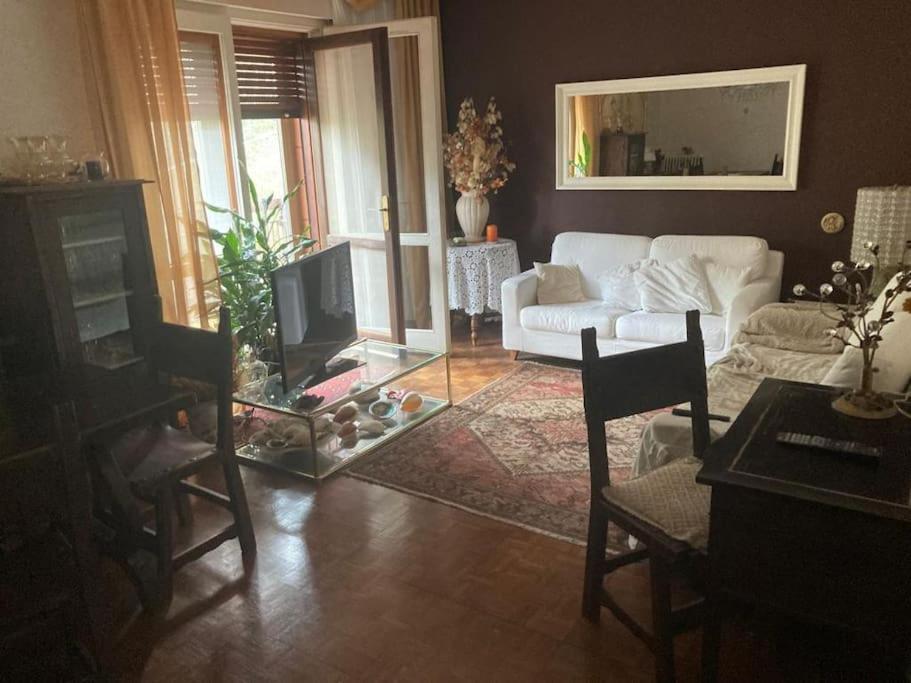 a living room with a white couch and a tv at La tua tranquilla casa a Trieste in Trieste