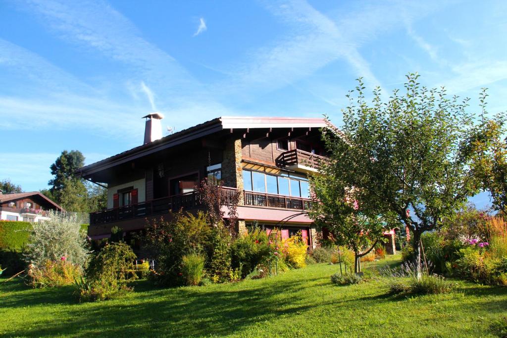 una casa grande en la cima de una colina con césped en 2 Appartements près de Megève et terrain de tennis en été en Demi-Quartier