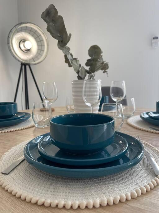 une table avec un bol bleu et des assiettes sur une table dans l'établissement La Bohème, à Challuy