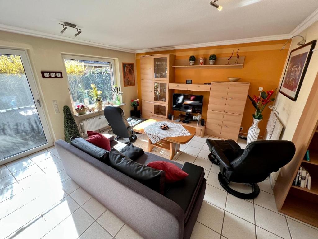 a living room with a couch and chairs and a table at Top ausgestattete Ferienwohnung in Stinteck nahe Büsum in Westerdeichstrich
