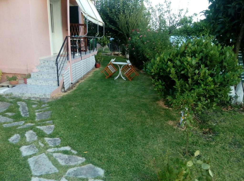 a backyard with a table and chairs in the grass at Sunny Room Lefkada in Lygia