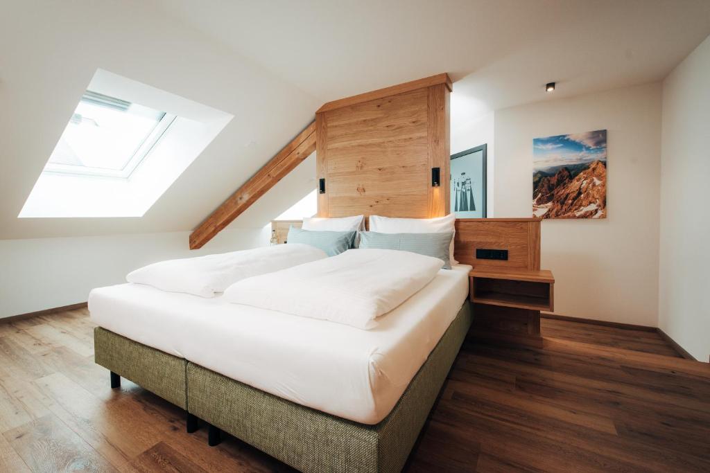 ein Schlafzimmer mit einem großen Bett und einem Dachfenster in der Unterkunft Hotel Drei König in Immenstadt im Allgäu