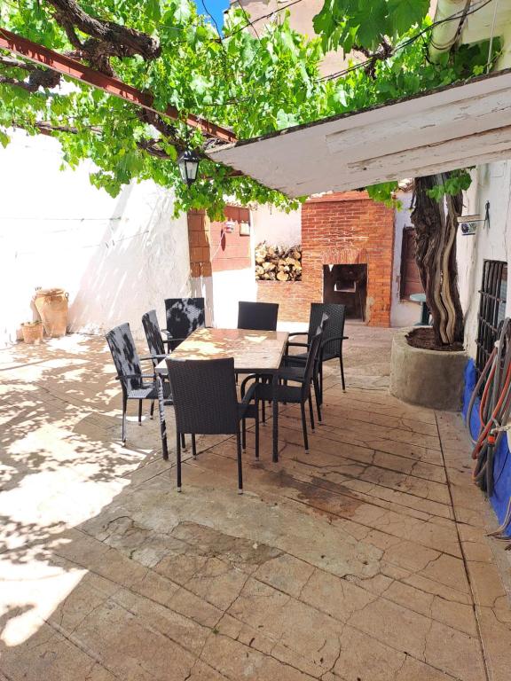 a patio with a table and chairs and a fireplace at Casa de La Parra in Valverde de Júcar