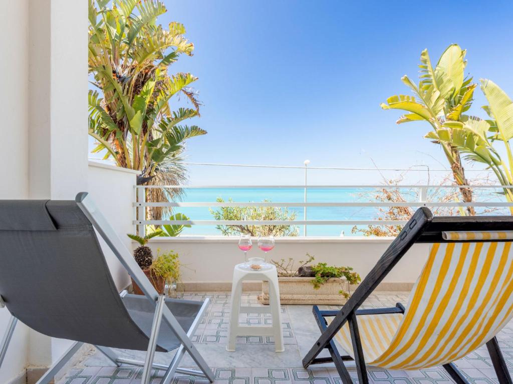 balkon z krzesłami i widokiem na ocean w obiekcie Studio Seccagrande by Interhome w mieście Borgo Bonsignore