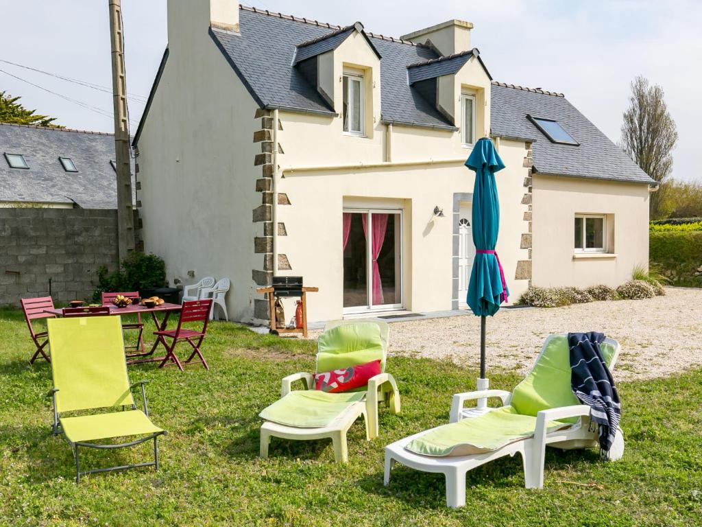 eine Gruppe Stühle und ein Regenschirm im Gras in der Unterkunft Holiday Home Va Zi Bihan - GUI111 by Interhome in Guissény