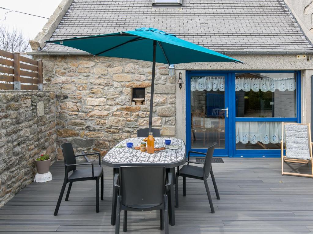 uma mesa e cadeiras com um guarda-sol num deque em Holiday Home Ty Kerveal - TEC210 by Interhome em Santec
