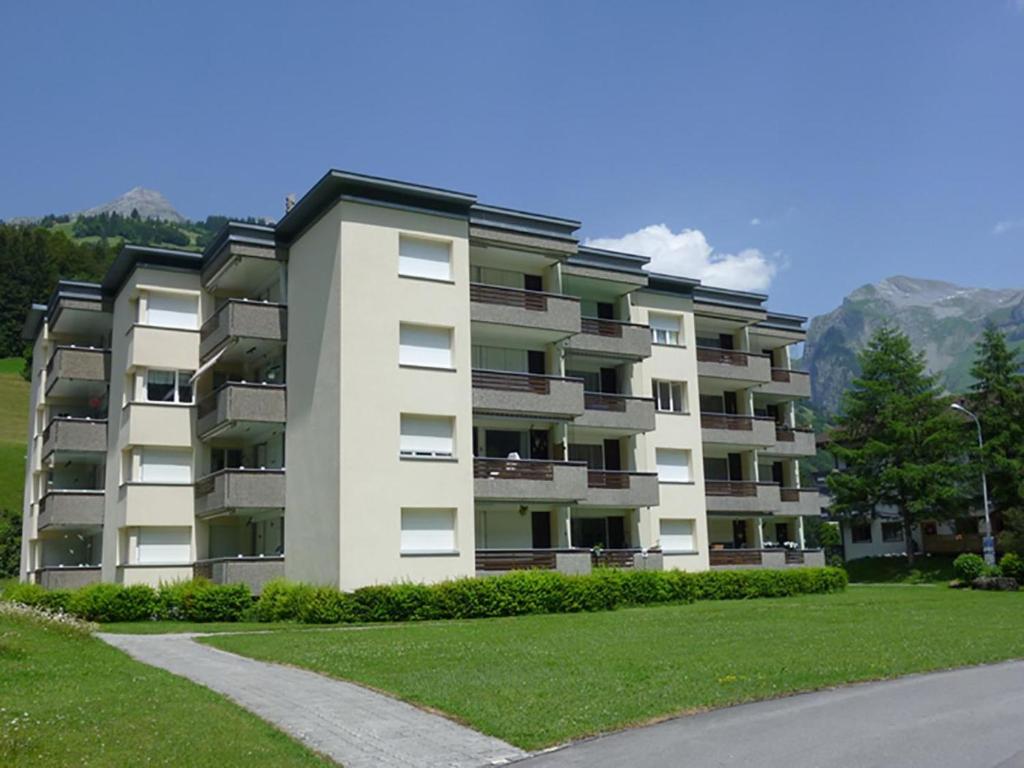 un grand immeuble d'appartements avec une pelouse verte en face de celui-ci dans l'établissement Apartment Sunnmatt Süd Wohnung 245 by Interhome, à Engelberg