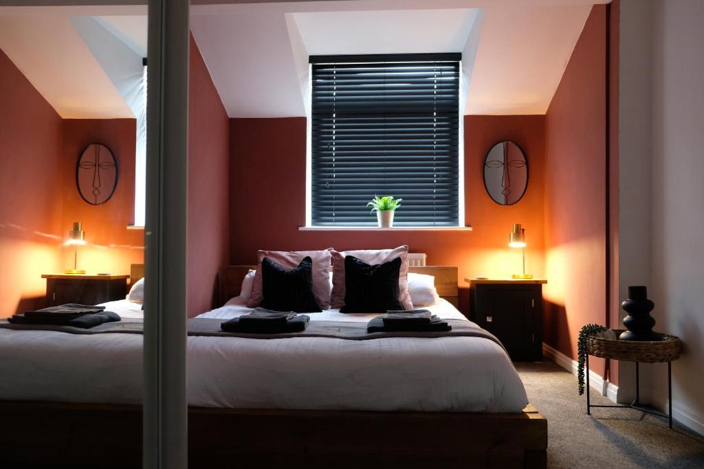 een slaapkamer met een bed met oranje muren en een raam bij Cosy Chester home - 0.6 miles from the centre in Chester