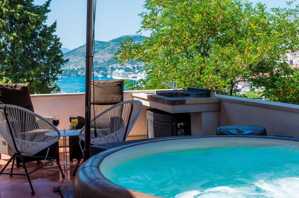 a hot tub on a patio with a table and chairs at Apartments Dub in Dubrovnik