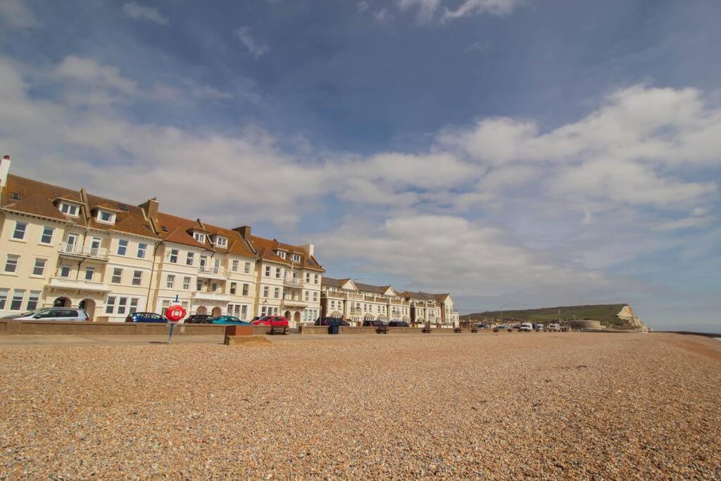 een rij gebouwen op een strand met een stopbord bij The Courtyard, 30 Seconds to Sea By Air Premier in Seaford