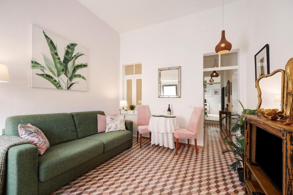 sala de estar con sofá verde y sillas rosas en Casa Doce en Silves