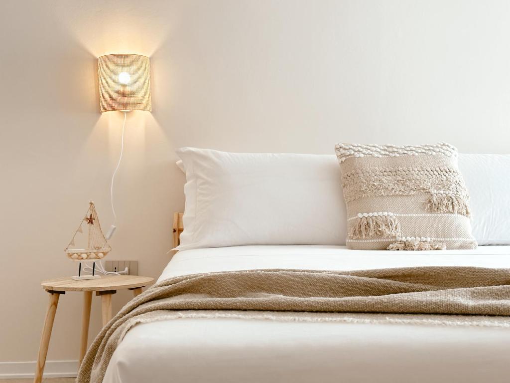 a bedroom with a white bed with a lamp at Tabbihome Apartments - Costa dei Trabocchi in Paglieta