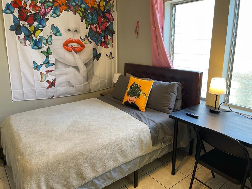 a bedroom with a bed with a desk and a painting at Best Value inside City Miami, Near Airport, Beach, Center & Metro in Miami