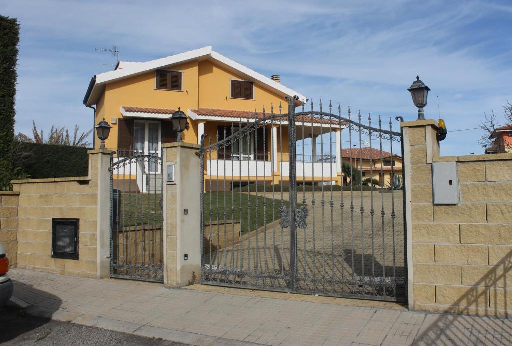 uma casa amarela atrás de uma cerca com um portão em Villa Wight em Olmedo