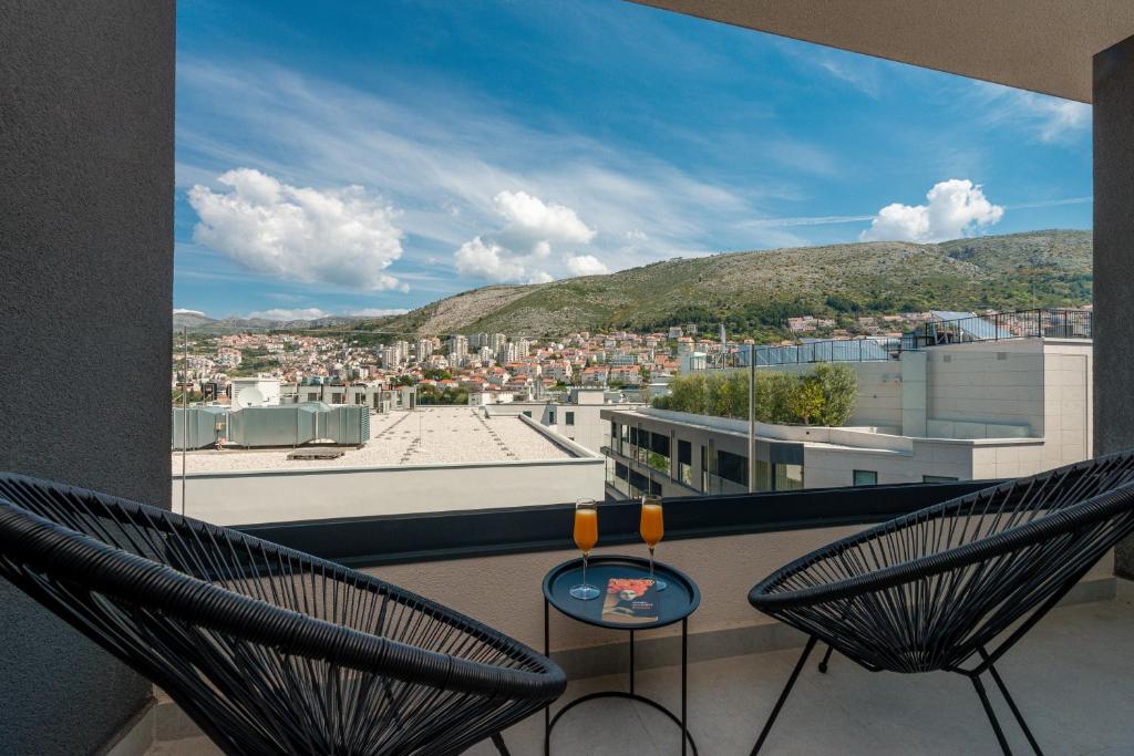 ein Balkon mit zwei Stühlen und Blick auf eine Stadt in der Unterkunft City Residences in Dubrovnik
