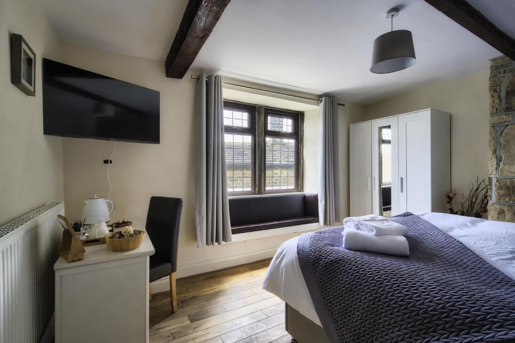 a bedroom with a bed and a tv and a window at The New Rushcart Inn & Country Dining in Sowerby Bridge