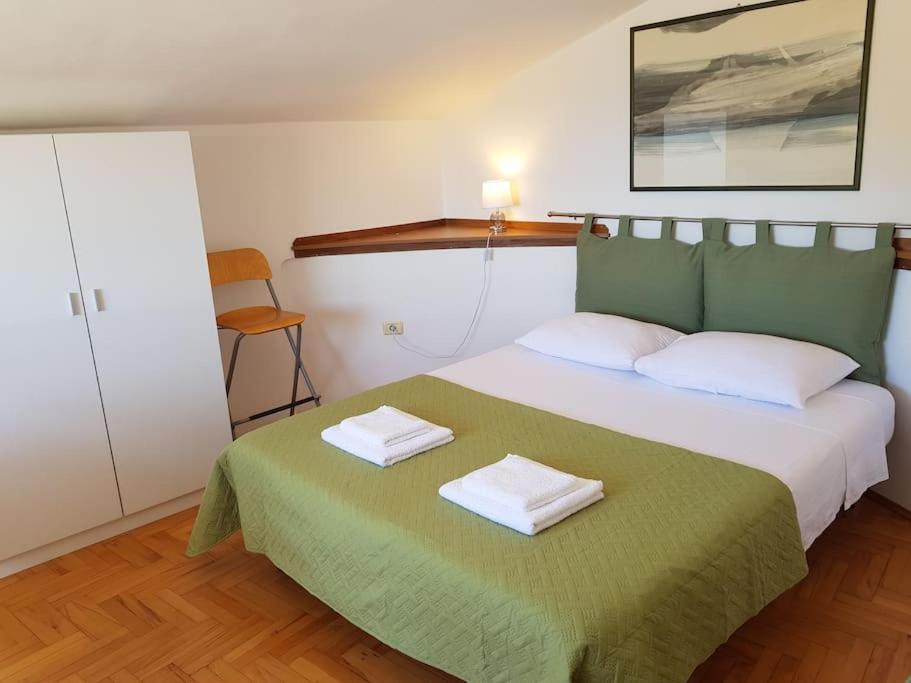 ein Schlafzimmer mit einem Bett mit zwei Handtüchern darauf in der Unterkunft Apartman Mare in Pješčana Uvala