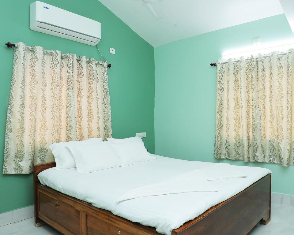 a bed in a room with green walls at Kopa Ville Resort in Shānti Niketan