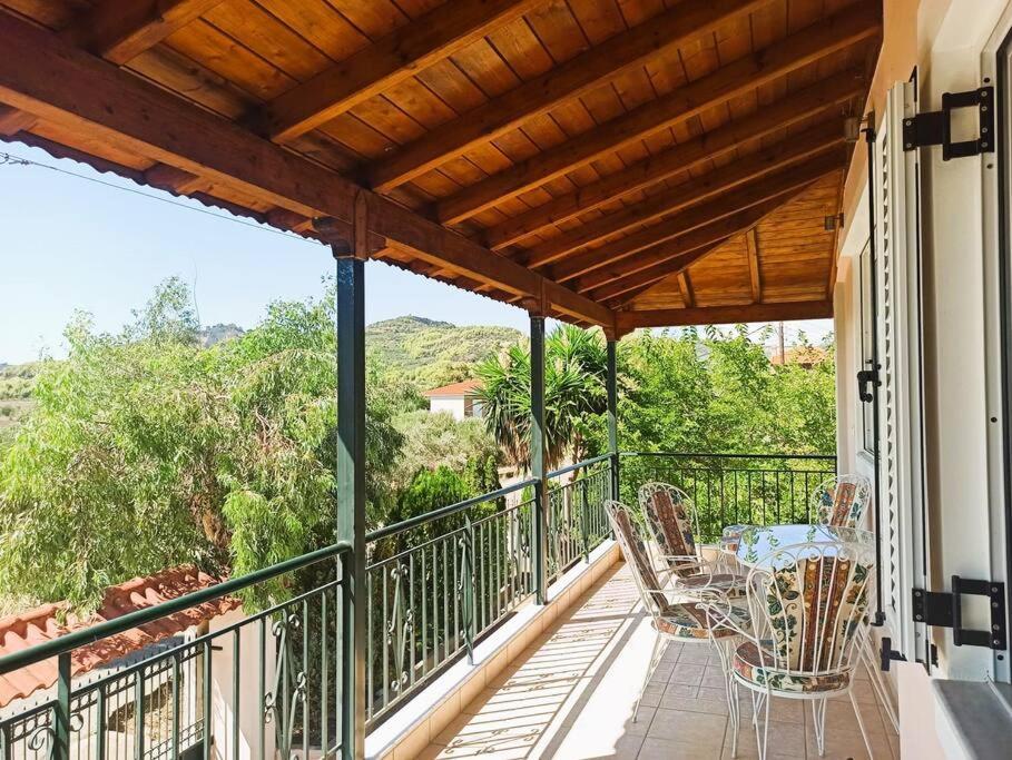 einen Balkon mit einem Tisch und Stühlen darauf in der Unterkunft Cottage in Greek nature in Pýrgos