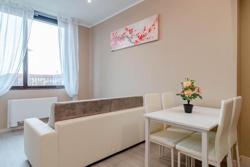 uma sala de estar com uma mesa branca e um sofá branco em Regina Apartment em Turim