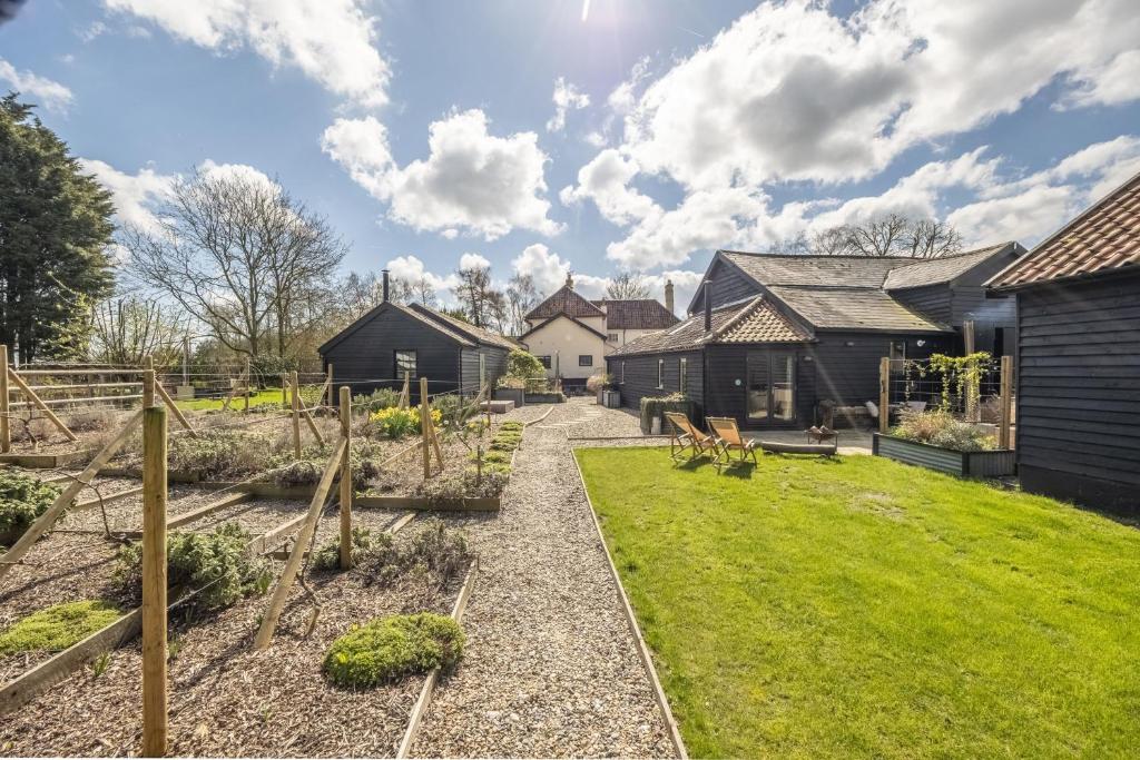 a garden in front of a house at The Firs Luxury Lodges and Glamping Tents in Cratfield