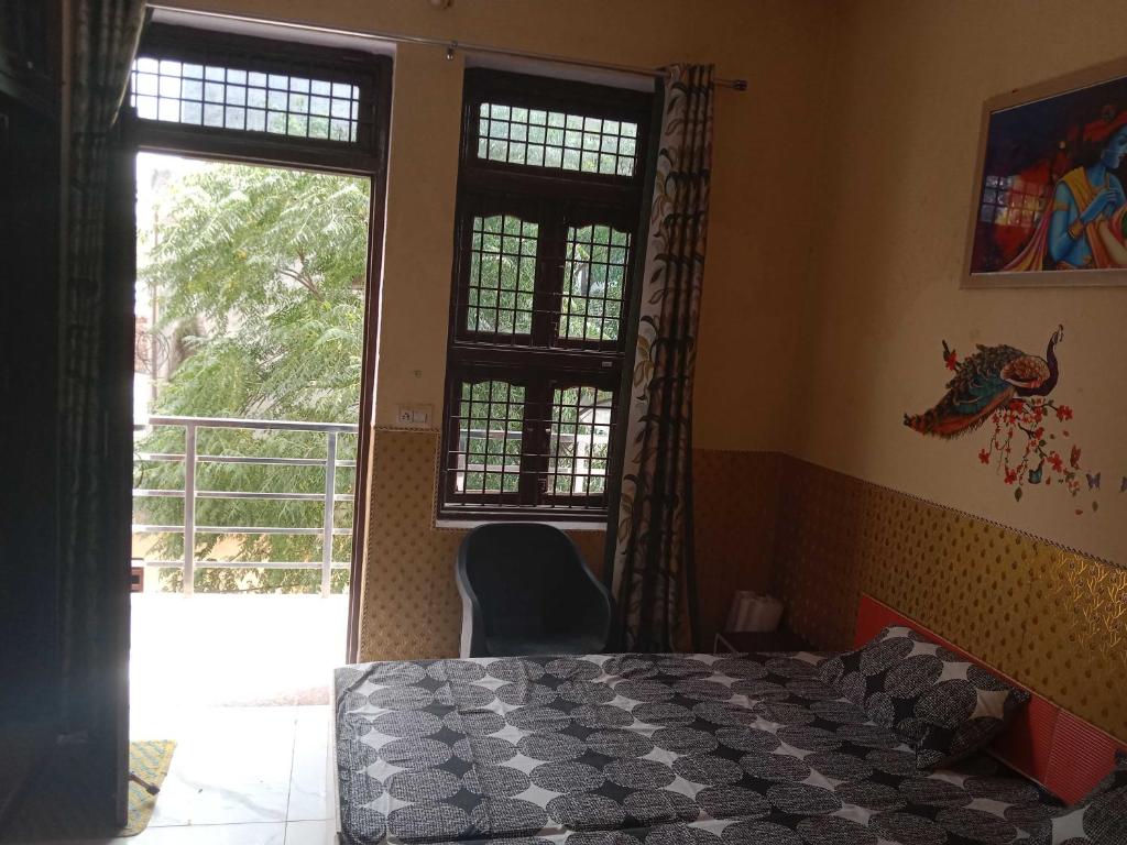 1 dormitorio con 1 cama, 2 ventanas y 1 silla en OYO Home Utsav Regency, en Manesar