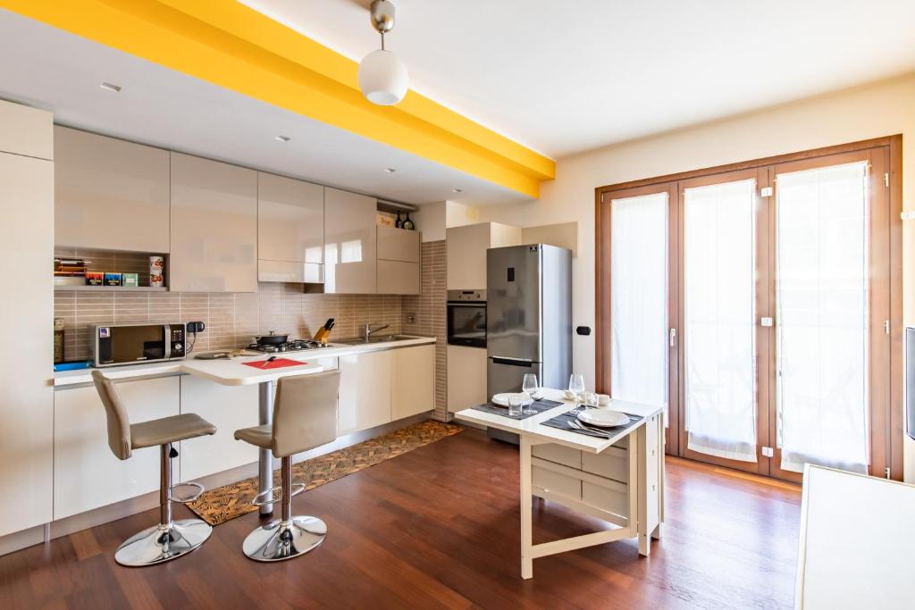 cocina con armarios blancos y techo amarillo en Duke Apartment - San Donato Milanese - by Host4U, en San Donato Milanese