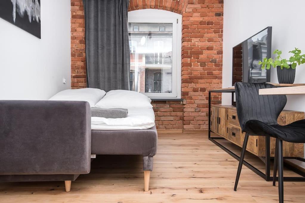 ein Schlafzimmer mit einem Bett und einer Ziegelwand in der Unterkunft Apartament Zwycięstwa in Gliwice