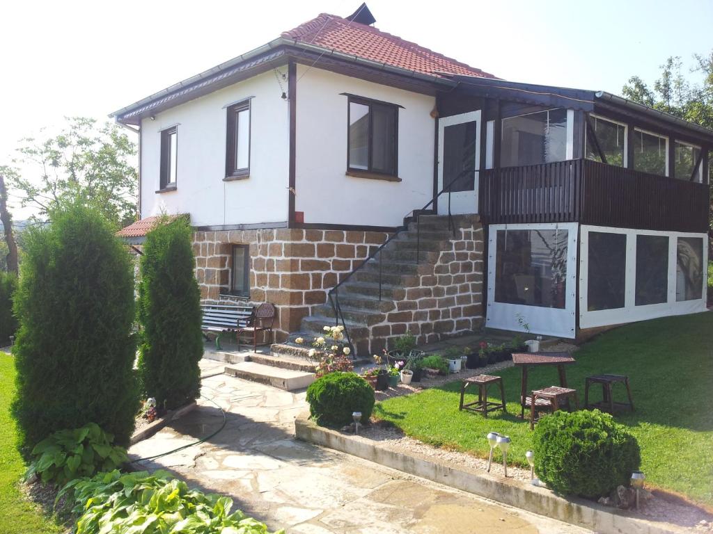 a white house with a yard with a patio at Guest House Relax in Dŭbravka