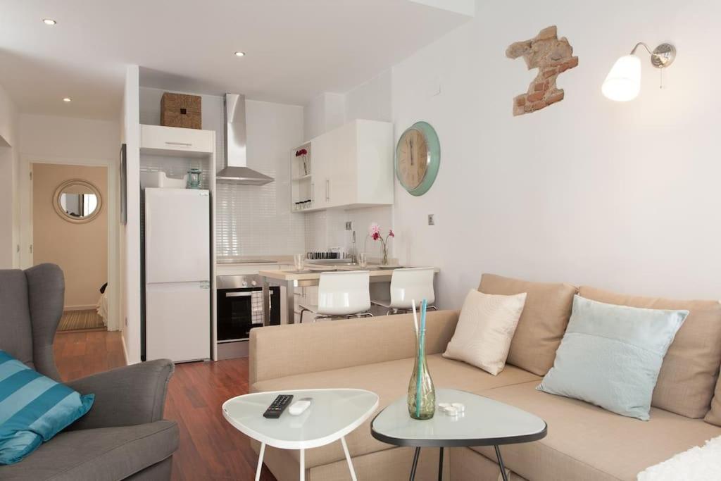 uma sala de estar com um sofá e mesas e uma cozinha em Flat in Bacelona Center em Barcelona
