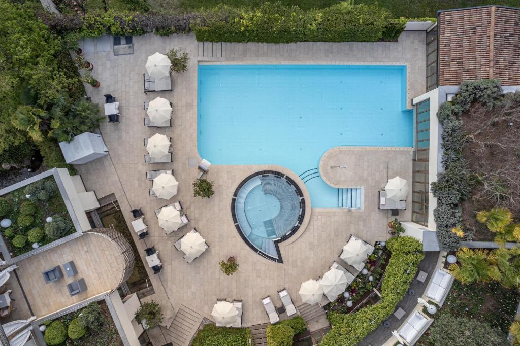 an overhead view of a swimming pool with lounge chairs and a pool table at Hotel Mignon Meran Park & Spa in Merano