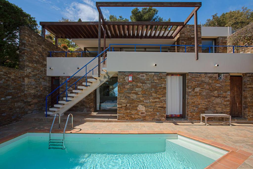 ein Haus mit einem Pool vor einem Gebäude in der Unterkunft Maison Piscine Vue mer in Bormes-les-Mimosas