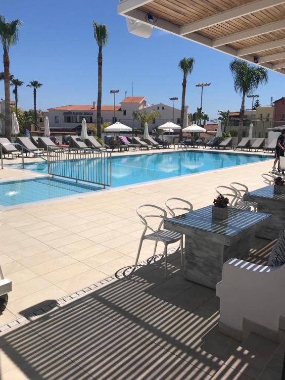 uma piscina com cadeiras e uma mesa num resort em Maria Holiday Apartments em Protaras