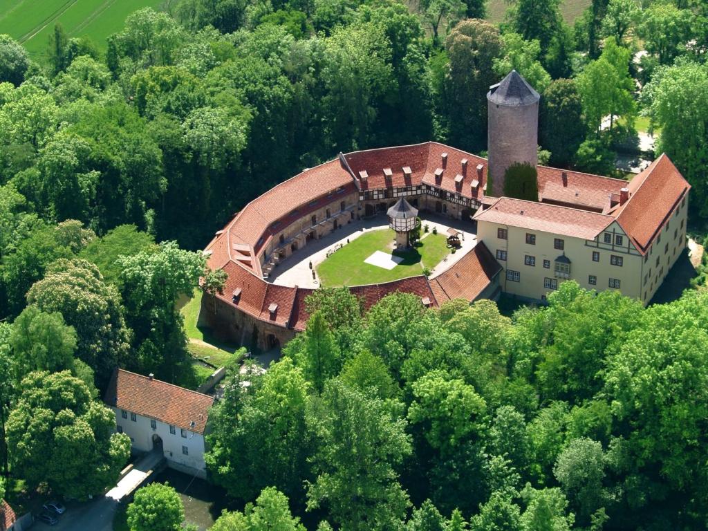 una vista aérea de una casa con una torre en los árboles en Hotel & Spa Wasserschloss Westerburg, en Westerburg