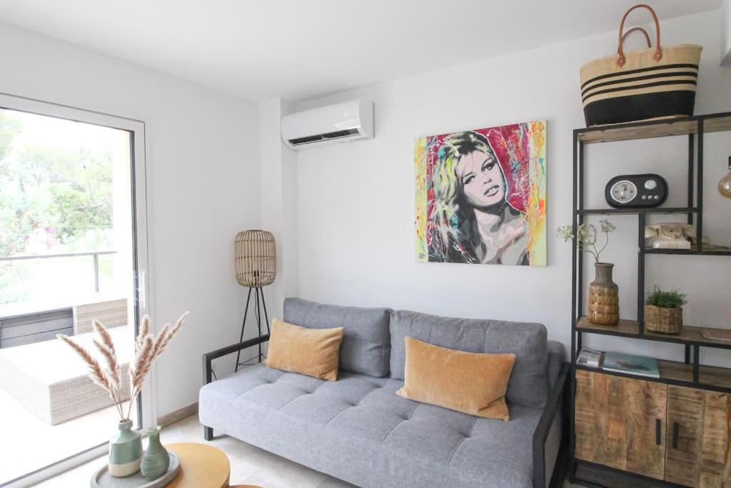 - un salon avec un canapé gris et une fenêtre dans l'établissement Appartement Kiel - Secret Beach - La Croix Valmer, à La Croix-Valmer